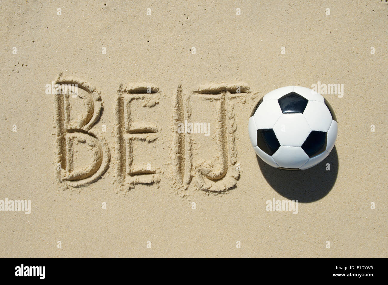 Beiji Football (kiss en portugais) message avec un ballon de soccer dans le sable à la main Banque D'Images