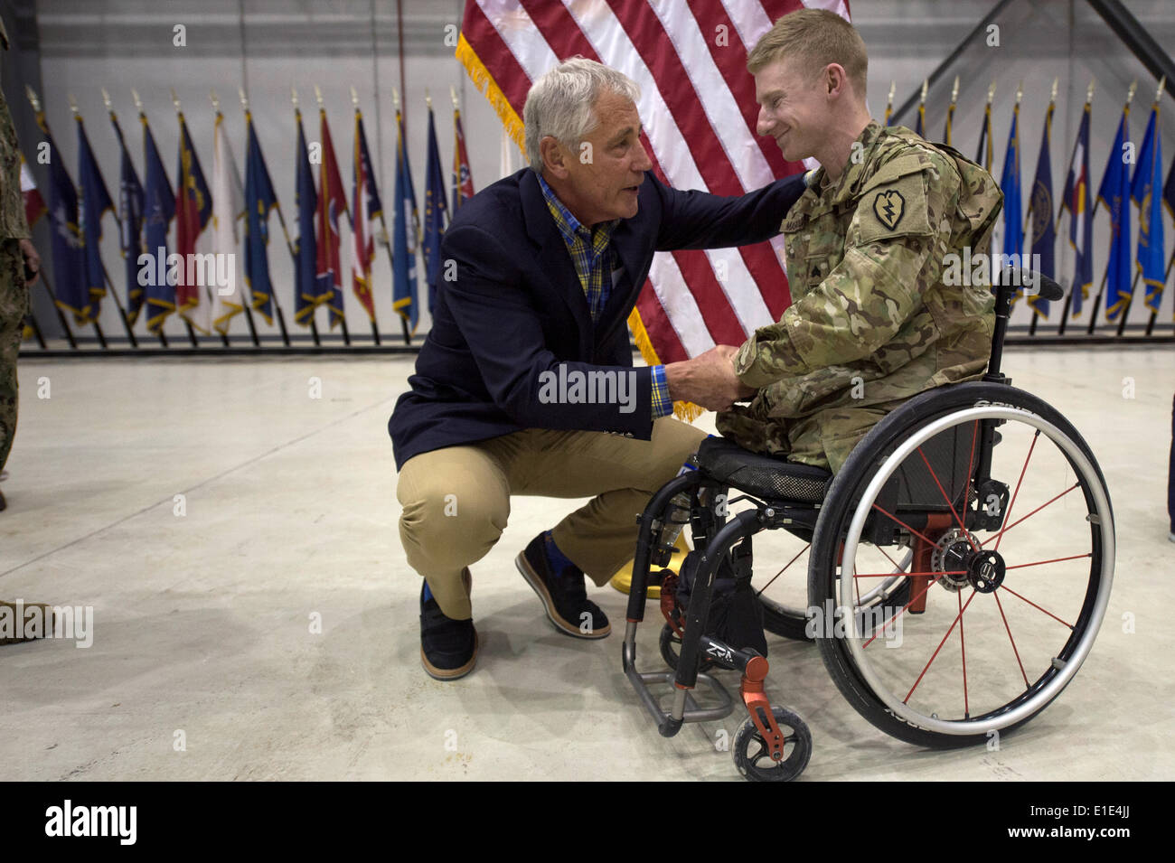 Le secrétaire américain à la défense Chuck Hagel parle d'un guerrier blessé le 1 juin 2014 lors d'une visite surprise à l'aérodrome de Bagram, en Afghanistan. Banque D'Images