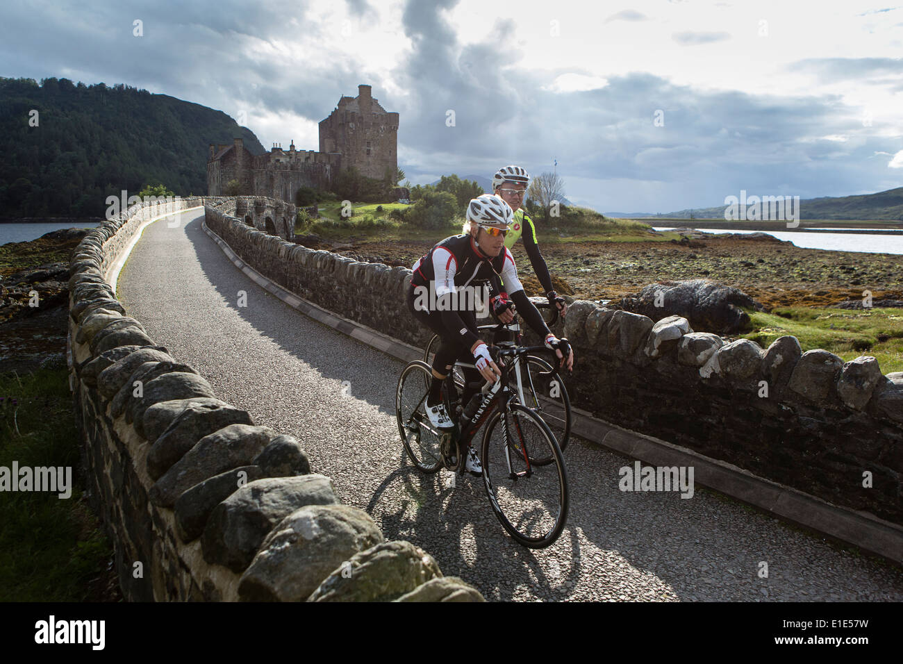 Paire de cyclistes roulent un chemin au sommet d'un haut mur de pierre sur l'île de Skye Banque D'Images