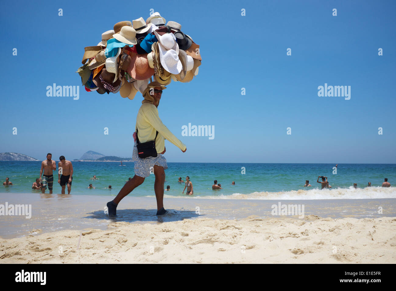 RIO DE JANEIRO, Brésil - le 22 janvier 2014 : : Plage vendeur vendre sa marchandise portant chapeaux promenades sur la plage d'Ipanema. Banque D'Images