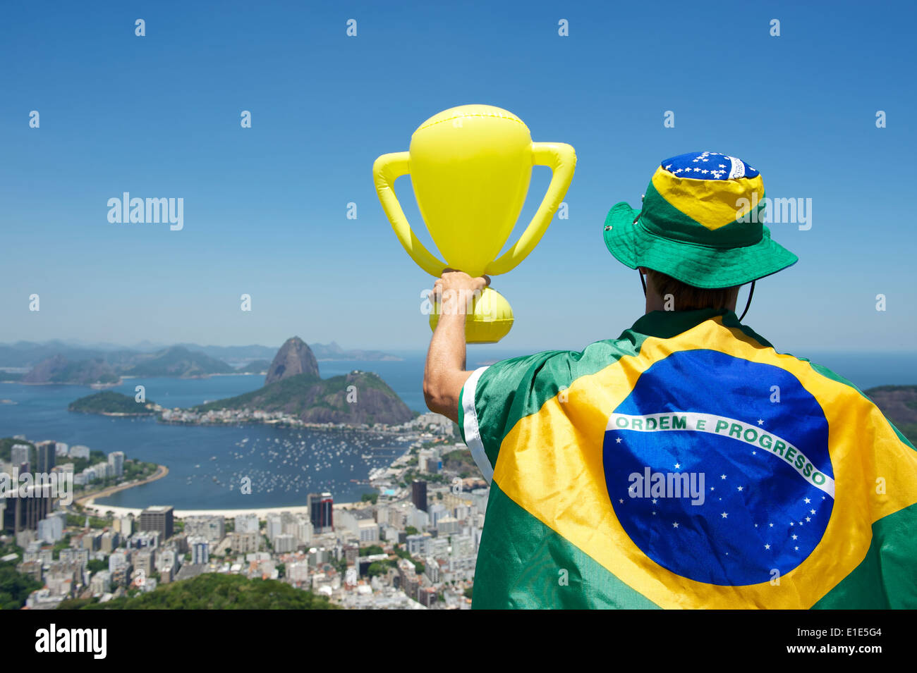 Champion du Brésil debout enveloppée dans un drapeau holding trophy de Sugarloaf Mountain View Botafogo Rio de Janeiro Brésil Banque D'Images