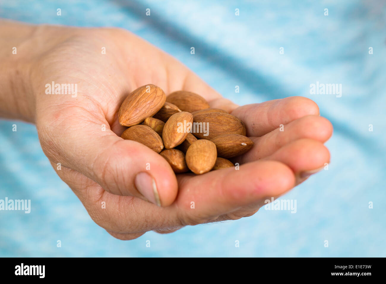 Main tenant un tas d'amandes bio Banque D'Images