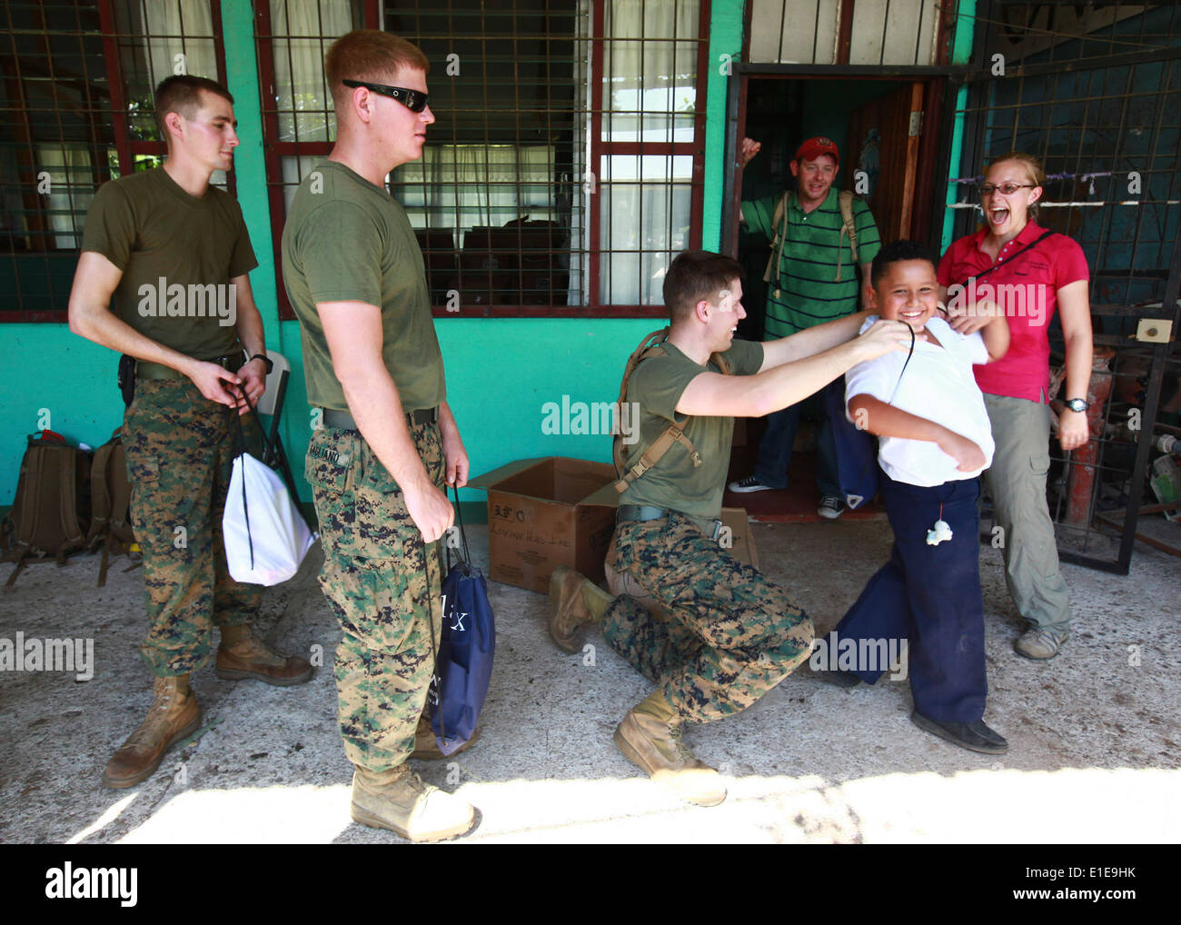 Le sergent du Corps des Marines des États-Unis. Kyle W. Cucci aide un enfant du Costa Rica mis sur un sac à dos rempli de fournitures scolaires à l'Hone Creek Scho Banque D'Images