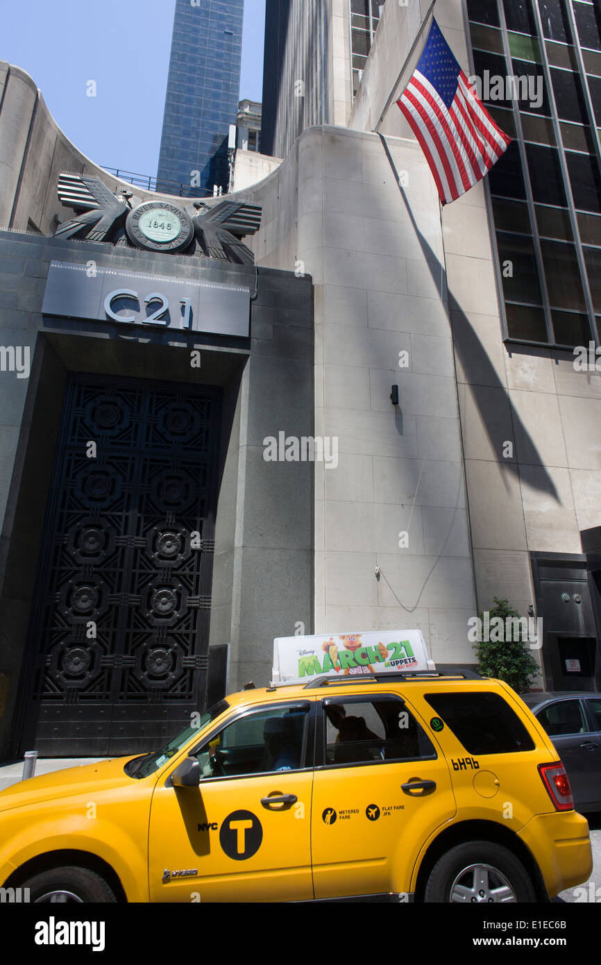 Un taxi hybride passe la grande porte de l'East River Savings Bank dans le Lower Manhattan, New York City. Banque D'Images