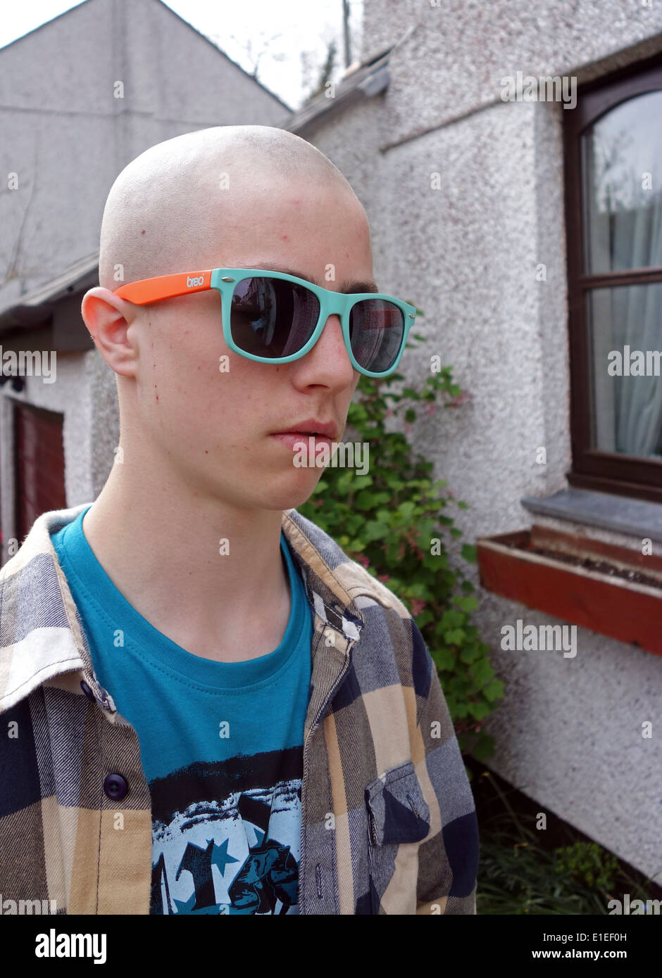 Un jeune garçon avec une coupe de skinhead Banque D'Images