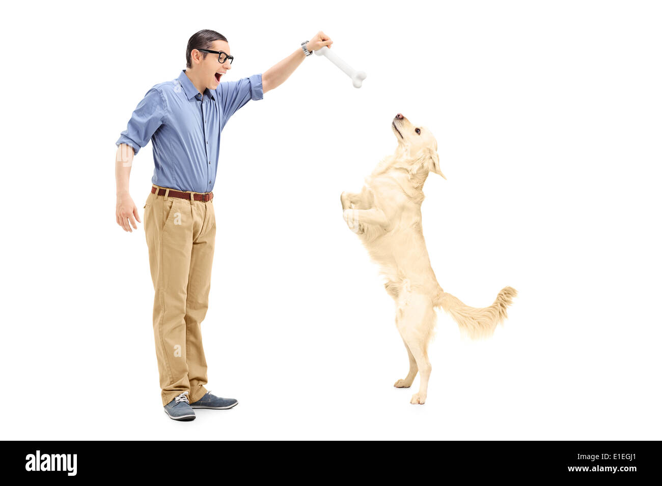 Jeune homme leurre d'un chien avec un os Banque D'Images