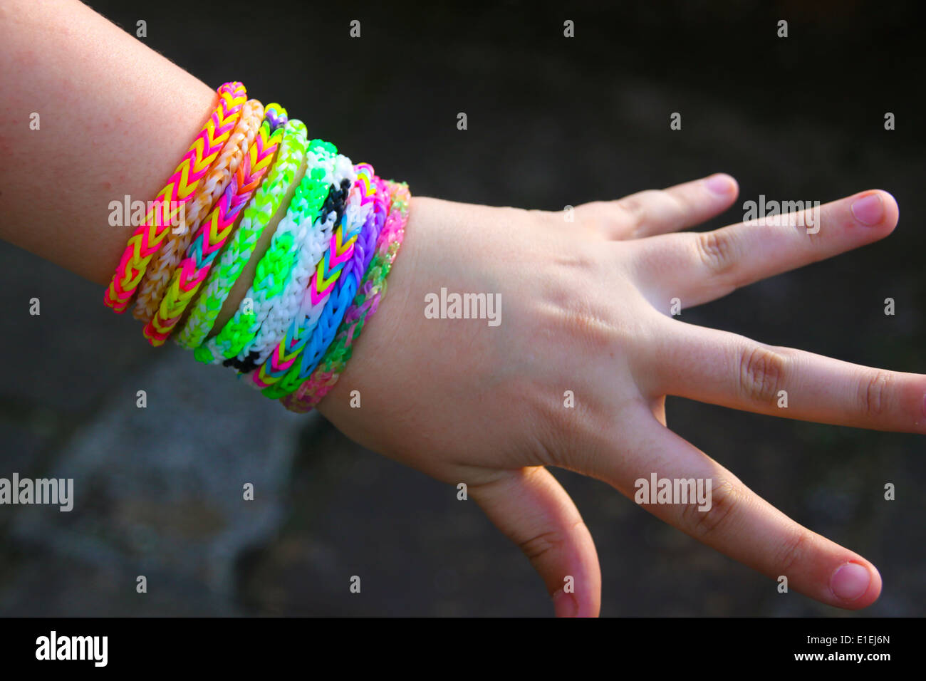 Jeune fille montrant outre de rainbow loom band bracelets à son poignet Banque D'Images