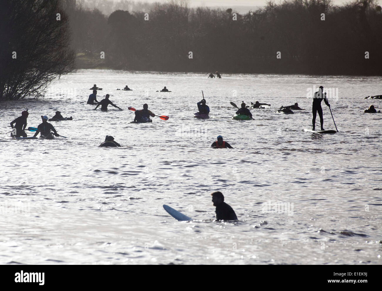 Les surfeurs et les gens dans des kayaks attendre dans la rivière Severn en prévision pour les cinq étoiles de l'alésage du bras Severn Banque D'Images