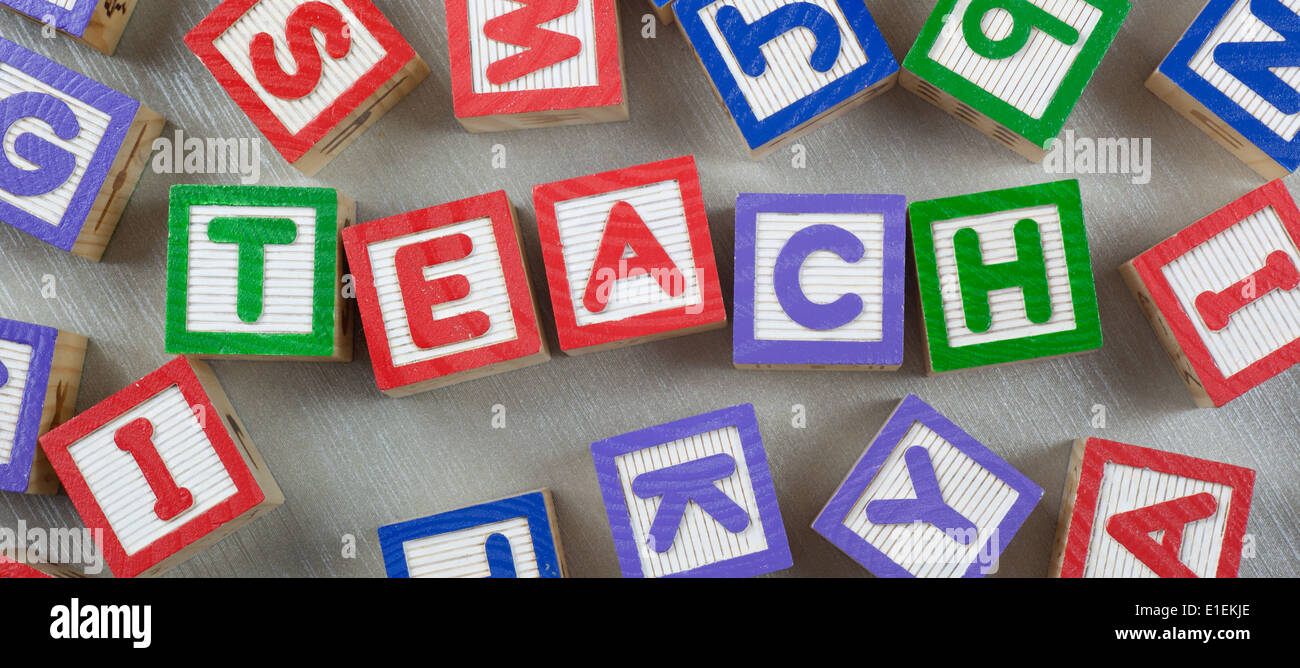 Des cales en bois formant le mot enseigner dans le centre Banque D'Images