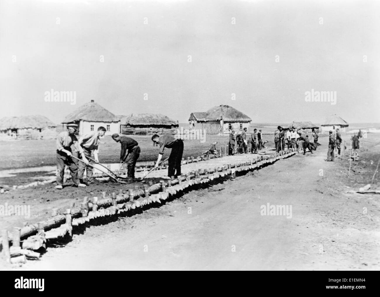 Texte de propagande! De l'information nazie sur le dos de la photo: "Prisonniers pendant la construction de la route. Loin derrière le front dans l'est, les prisonniers sont utilisés pour poser des routes en velours côtelé sur les terrains marécageux. » Photo du Front de l'est, 19 juin 1942. (Défauts de qualité dus à la copie historique de l'image) Fotoarchiv für Zeitgeschichtee - PAS DE SERVICE DE FIL - Banque D'Images