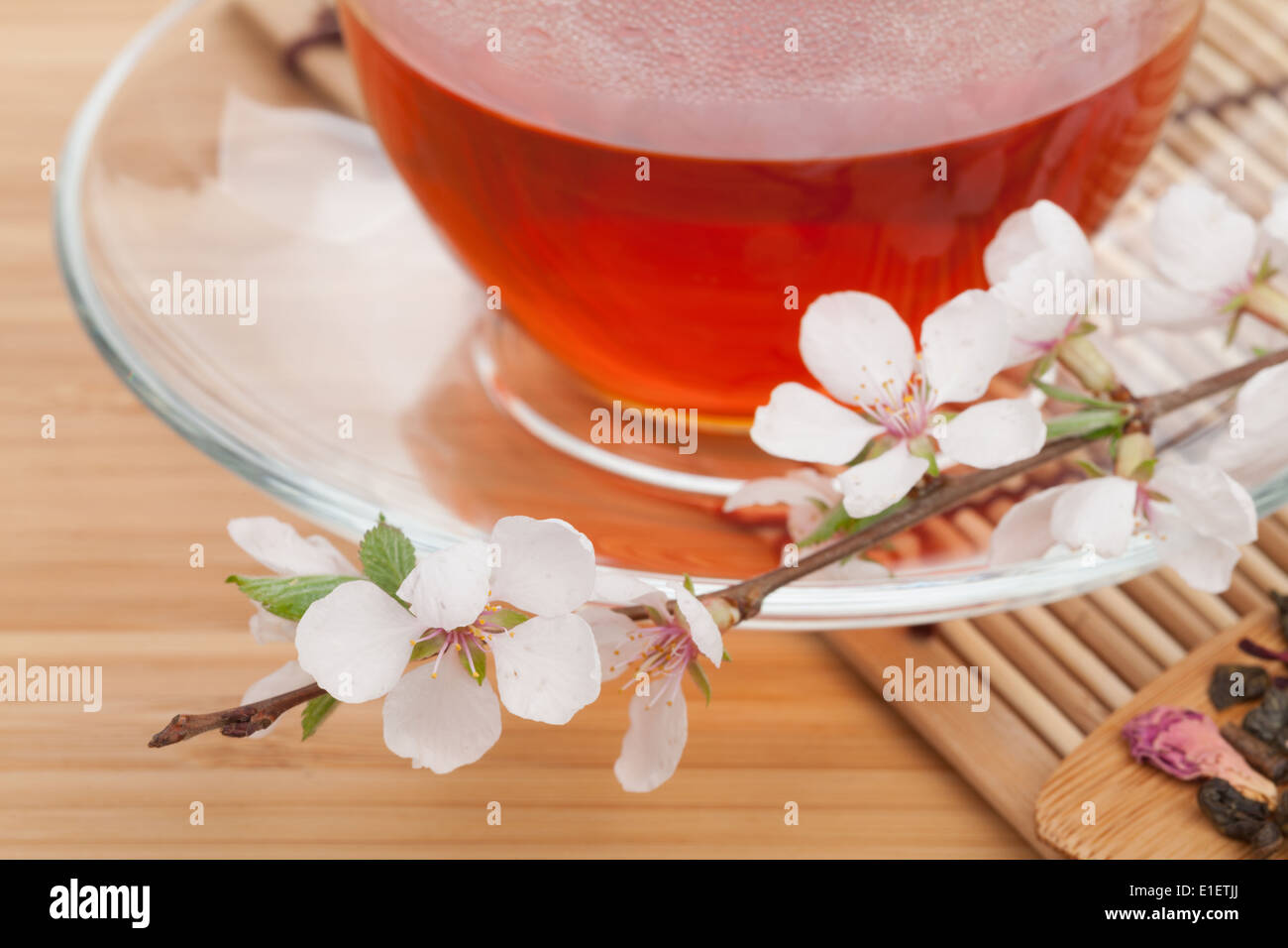 Le thé vert japonais et sakura direction générale au cours de mat et table en bambou. Se concentrer sur la fleur avant Banque D'Images