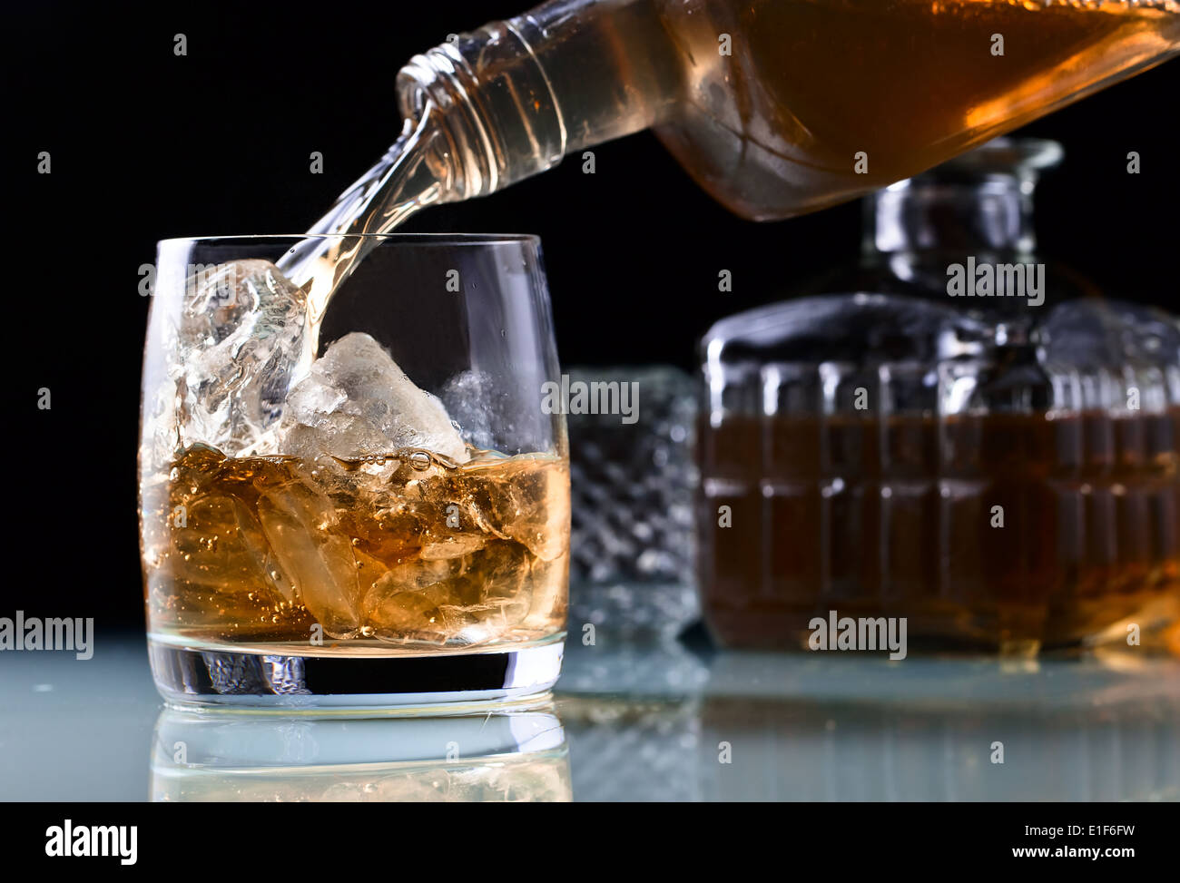 Verre à whisky et de la glace sur une table en verre Banque D'Images