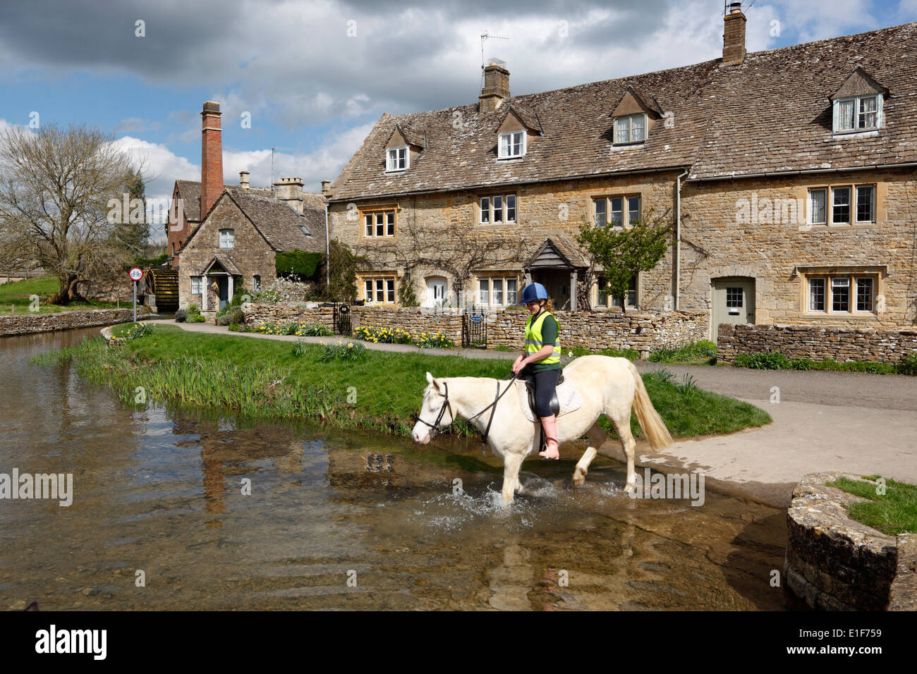 Pony dans la rivière oeil avec le Old Mill Museum, Lower Slaughter, Cotswolds, Gloucestershire, Angleterre, Royaume-Uni, Europe Banque D'Images