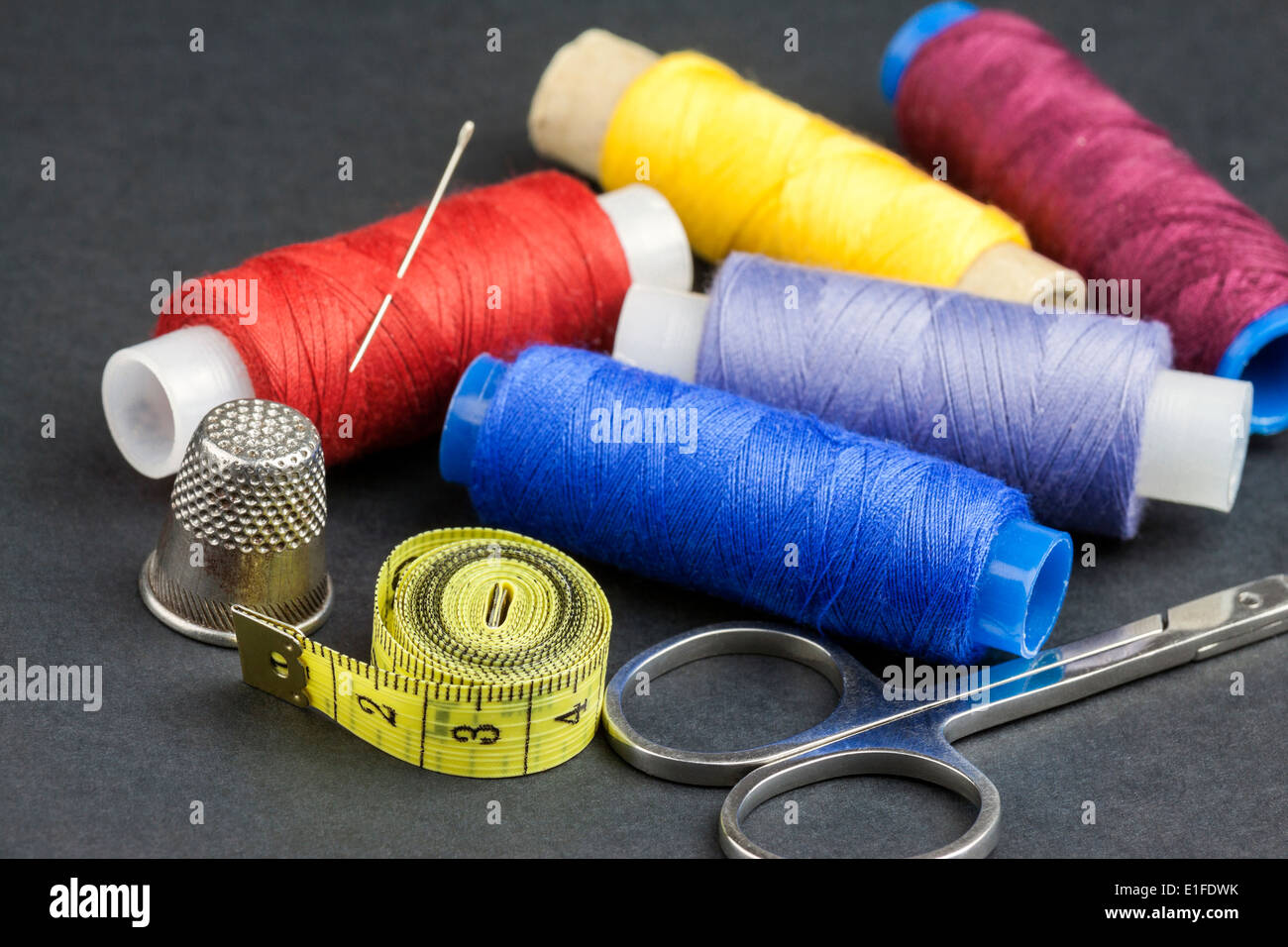 Outils de tailleurs - des ciseaux, des bobines de fil, de mesurer, d'aiguille et dé - isolé sur fond noir Banque D'Images
