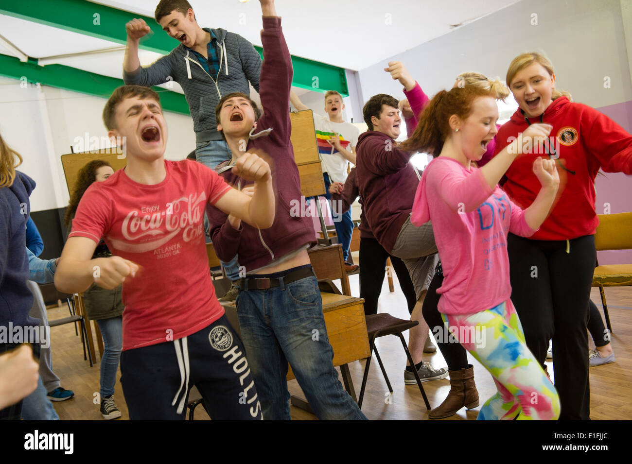 Un groupe d'adolescents dans le théâtre pour la jeunesse à répéter le chant et le théâtre pour un spectacle de théâtre musical, UK Banque D'Images