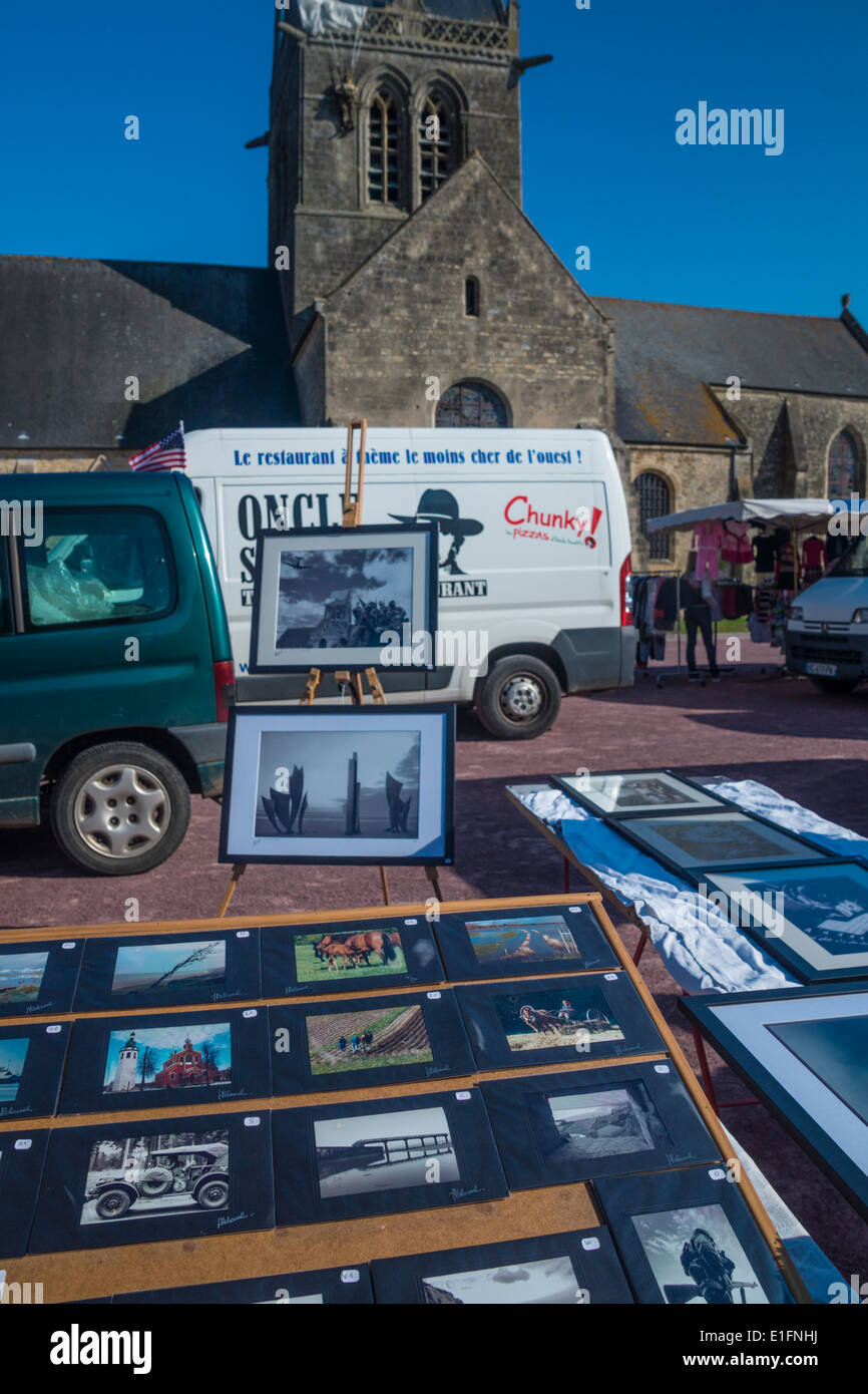 Ste. Mere-Eglise, Normandie, France. Un stand vendant des images de guerre et d'un camion de restauration rapide en face de l'Église. Banque D'Images