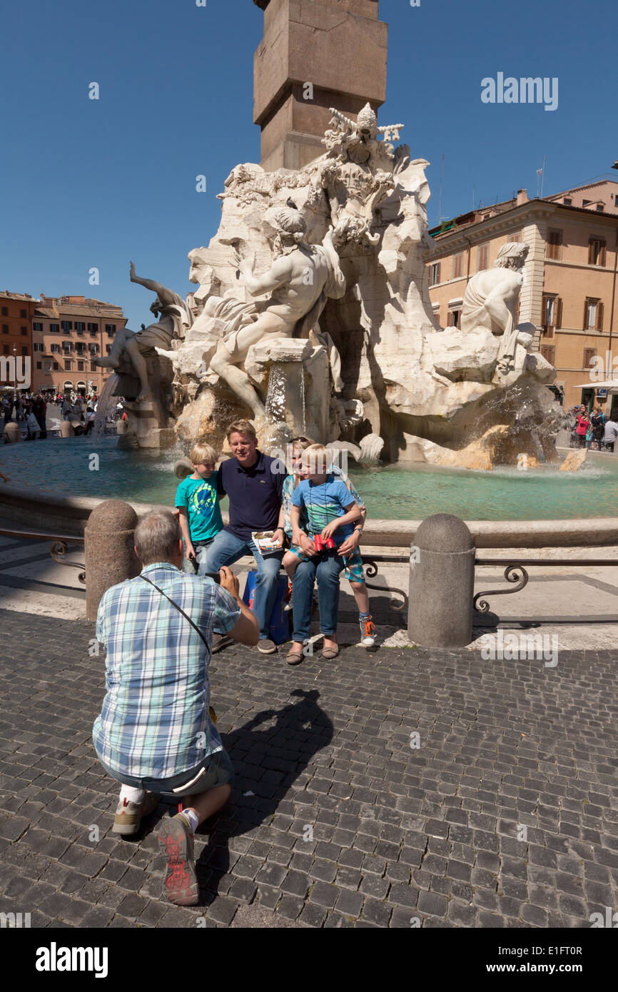 Une famille en vacances à Rome ayant une photo par les quatre fleuves fontaine du Bernin, Piazza Navona, Rome Italie Europe Banque D'Images