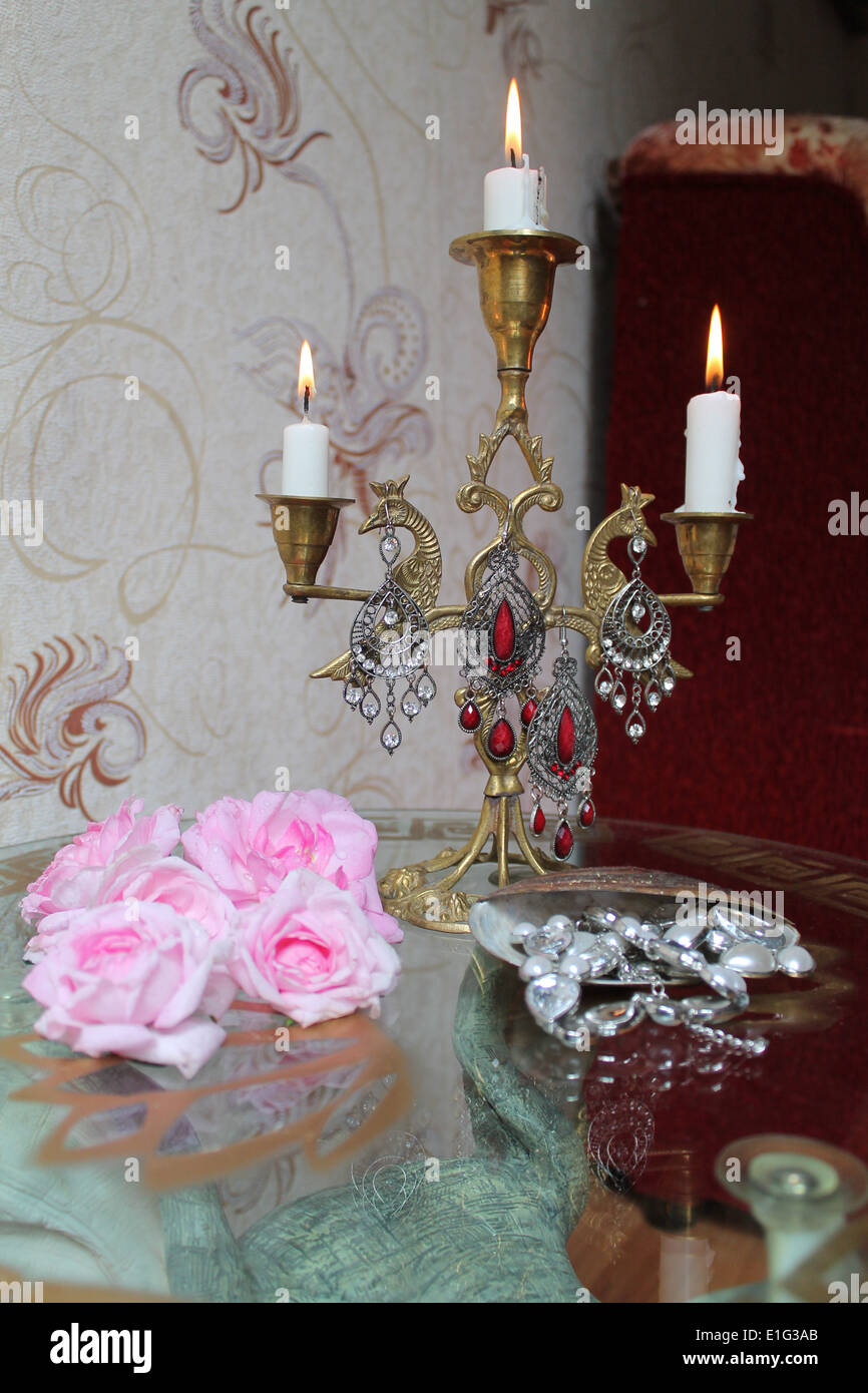 Vieux candélabre en bronze avec brûler des bougies, des roses roses et shell avec collier Banque D'Images