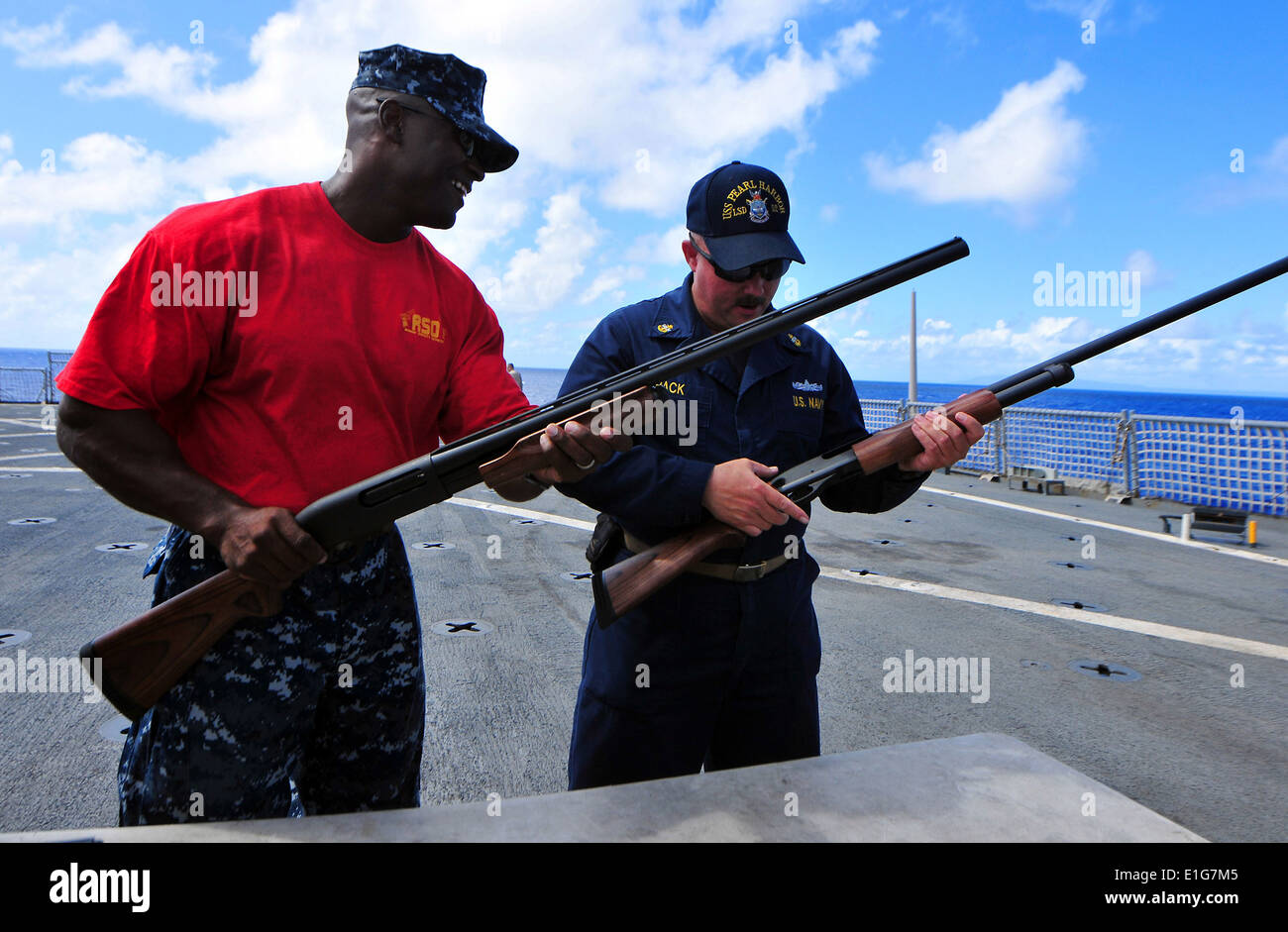 Chef principal de la Marine américaine Master-at-Arms Robert Goode, à gauche, et l'Artilleur en chef ?s'accoupler Blair Pack inspecter 12 fusils de calibre au cours d'une Banque D'Images