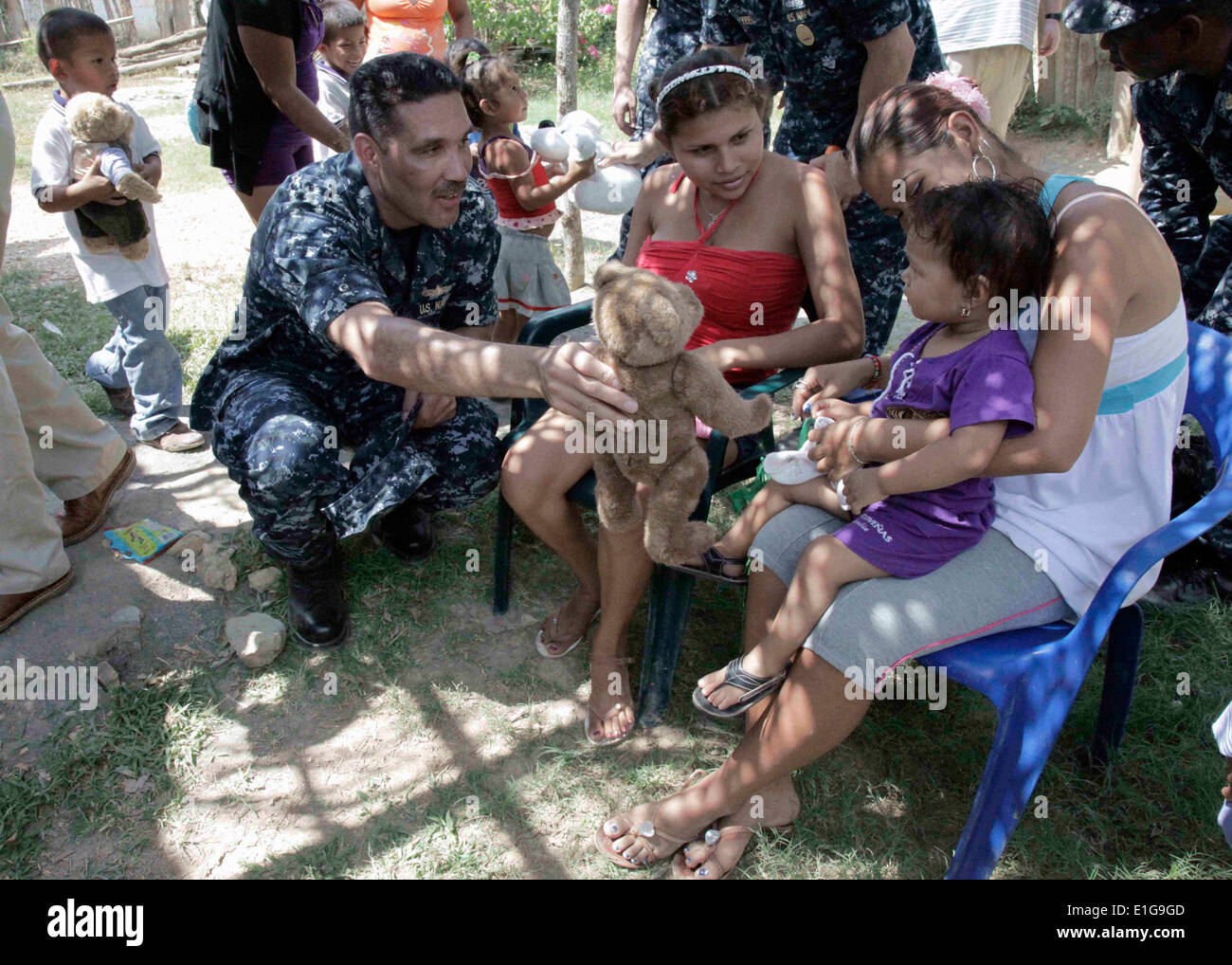 Le Capitaine de vaisseau américain Brian Nickerson, commandant de mission pour Amphibious-Southern Partenariat Station 2011, donne un enfant un nounours Banque D'Images