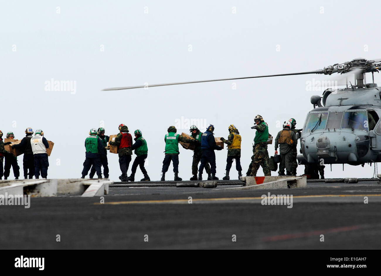 110315-N-GL340-170 ouest de l'OCÉAN PACIFIQUE (Mars 15, 2011) - Les Marins apporter de la nourriture et de l'eau sur un HH-60H Sea Hawk, affectés à la Banque D'Images