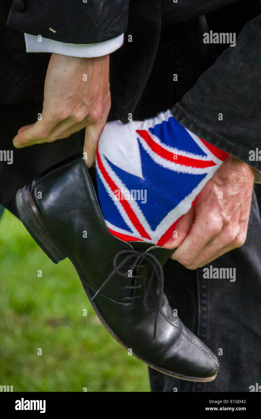 Un Anglais met sur smart shoes sur Union flag chaussettes. Banque D'Images