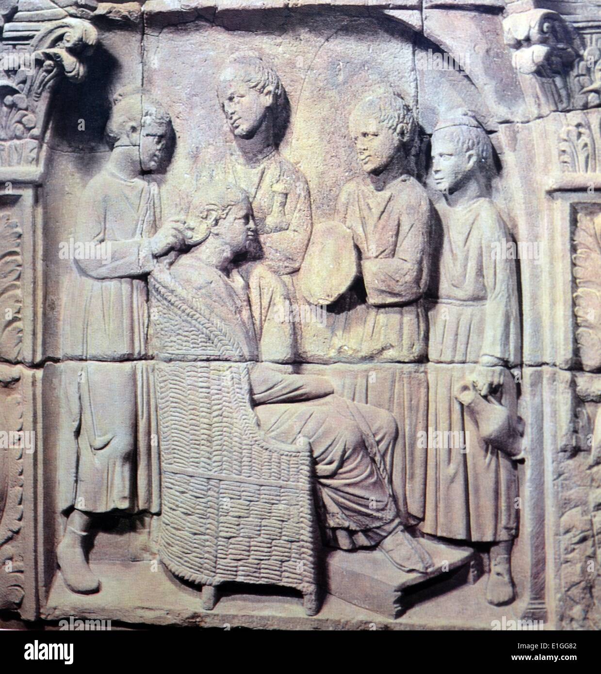 Scène pierre représente une riche dame assise dans un fauteuil en osier soutenu avec ses pieds reposant sur un tabouret. Ses quatre filles d'esclaves s'affairent autour d'elle : l'un est titulaire d'une fiole de parfum, une seconde pose un miroir, un troisième attend avec une petite cruche, et organiser ses cheveux sont l'ornatrix - un membre important de l'esclave au domicile qui a également vu à la rouge, lip-stick et eye-shadow. En date du 1er siècle avant J.-C. Banque D'Images