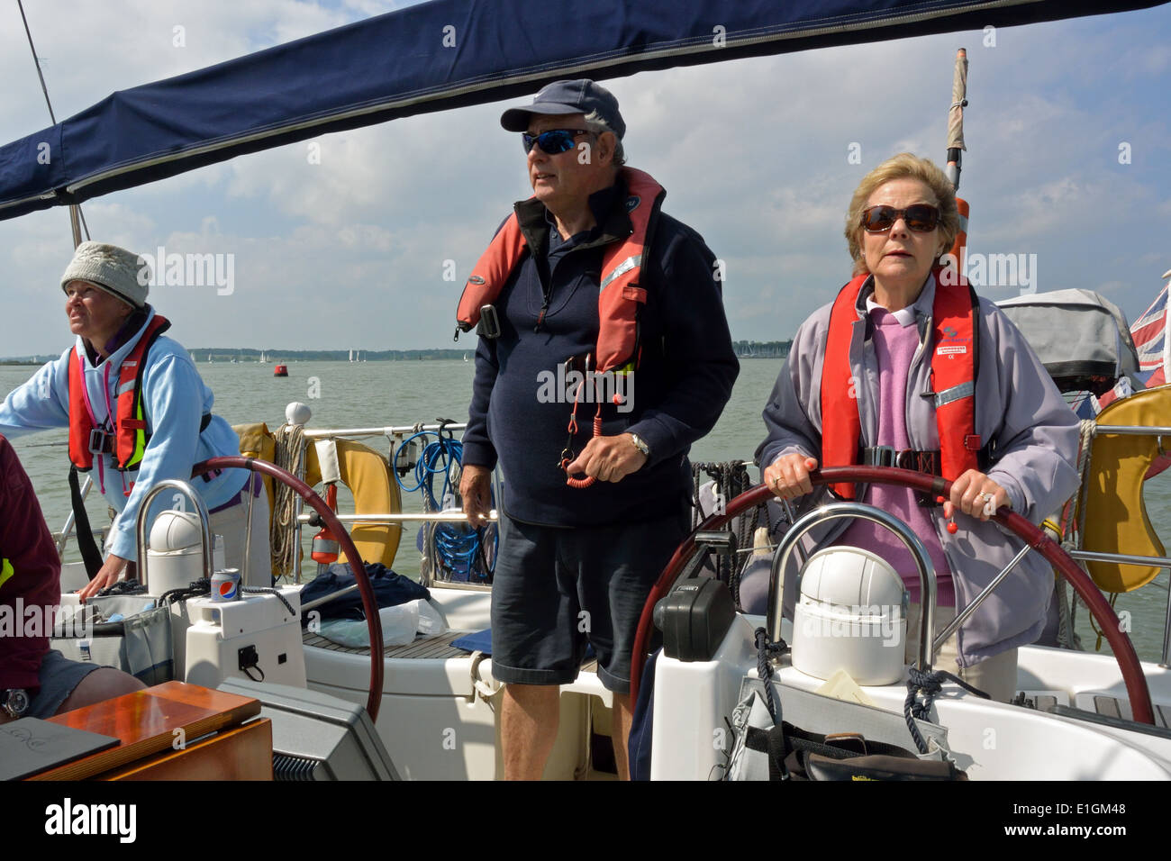 Patron et l'équipage sur les navigateurs vikings Bénéteau Océanis Clipper 473 cruising yacht à voile bleu Viking sur la rivière Orwell, Suffolk Banque D'Images