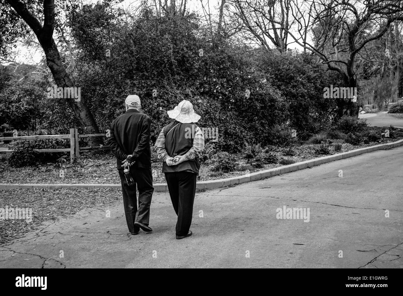Vieux couple marchant dans jardin. Banque D'Images