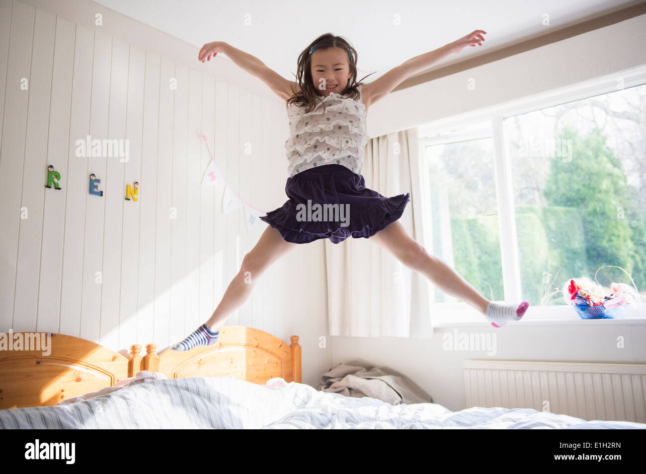 Young Girl jumping mid air on bed Banque D'Images