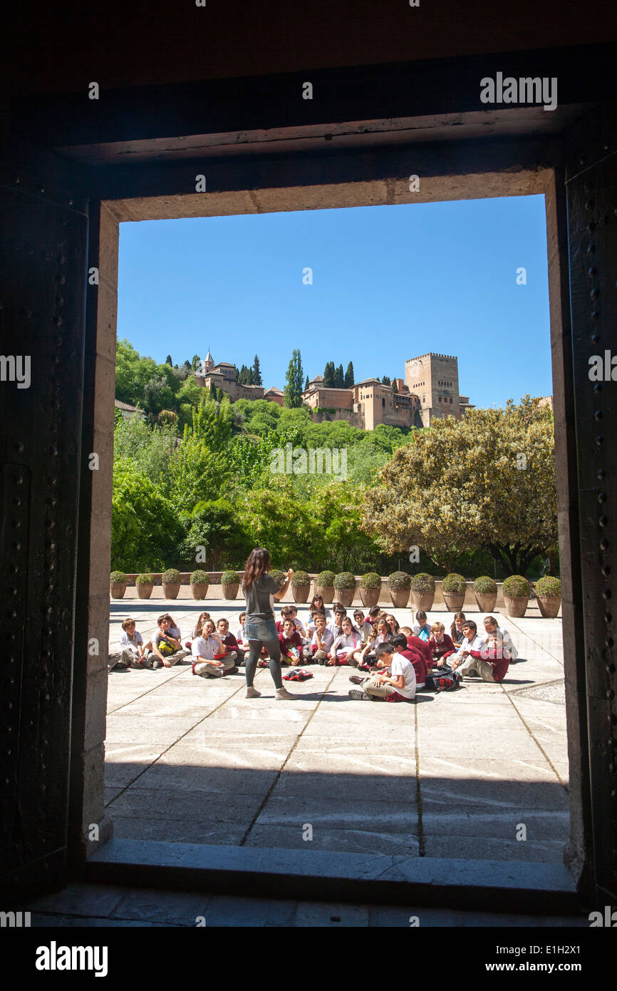 Les enfants de l'école d'écouter leur professeur sur une visite éducative pour les sites historiques de Grenade, Espagne Banque D'Images