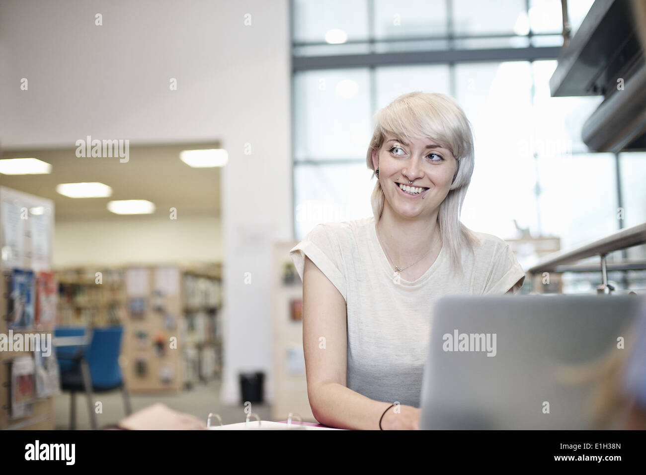 Young woman using laptop in library Banque D'Images