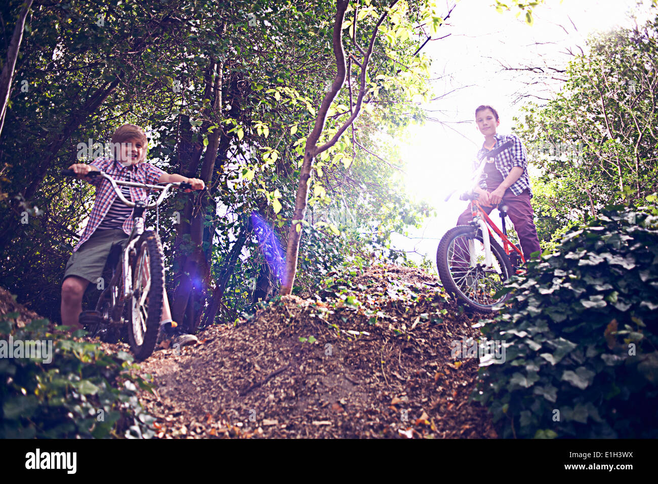 Les garçons à travers la forêt à vélo Banque D'Images