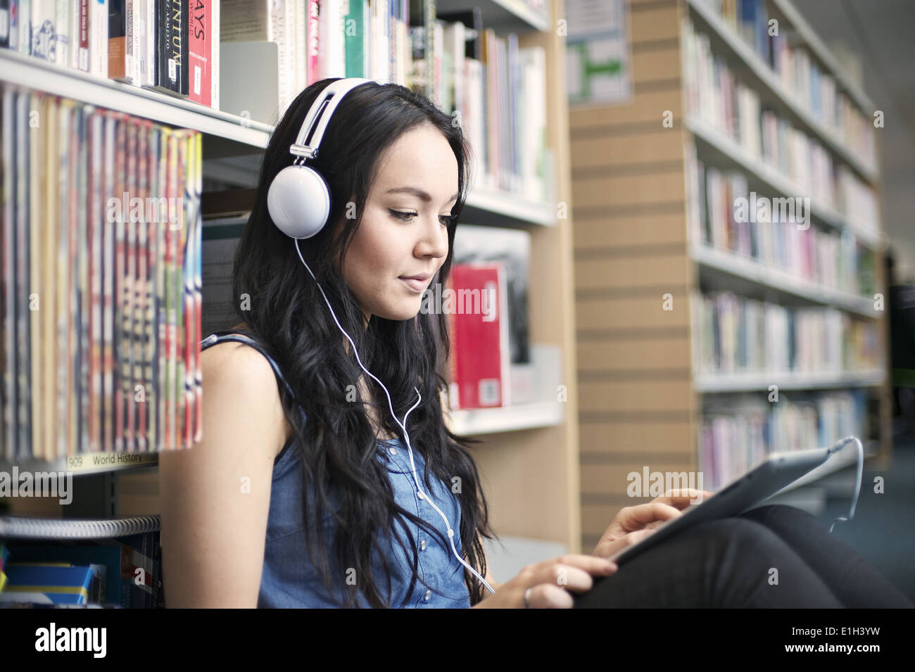 Young woman wearing headphones using digital tablet Banque D'Images