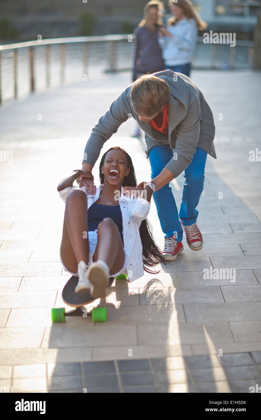 Jeune couple couchait sur planche à Riverside Banque D'Images