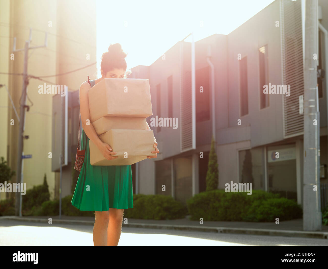 Young woman carrying et jeter plus de pile de cartons Banque D'Images