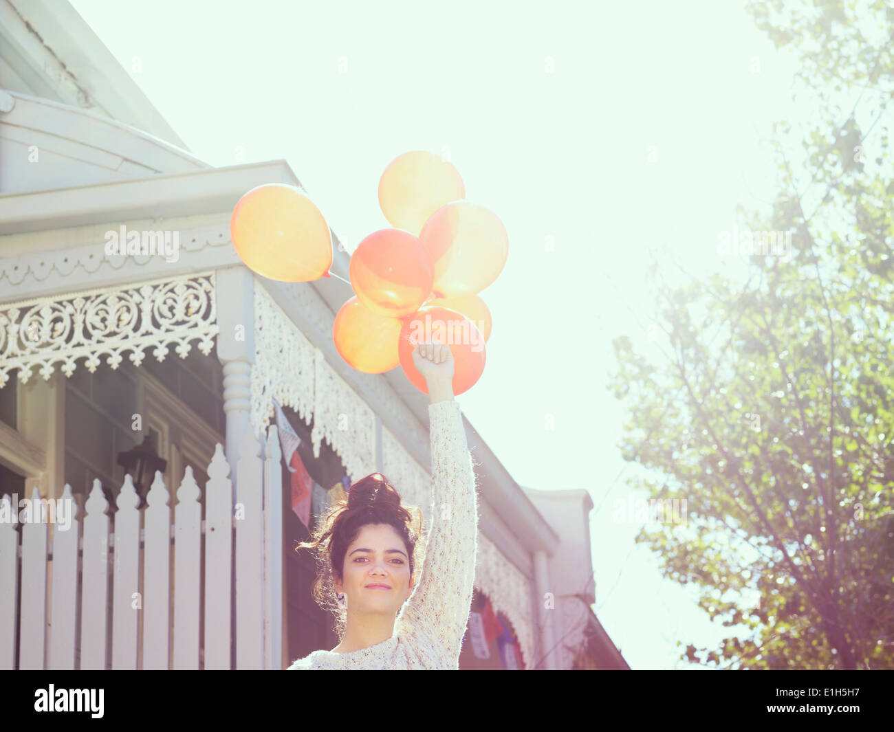 Portrait de jeune femme tenant un bouquet de ballons Banque D'Images