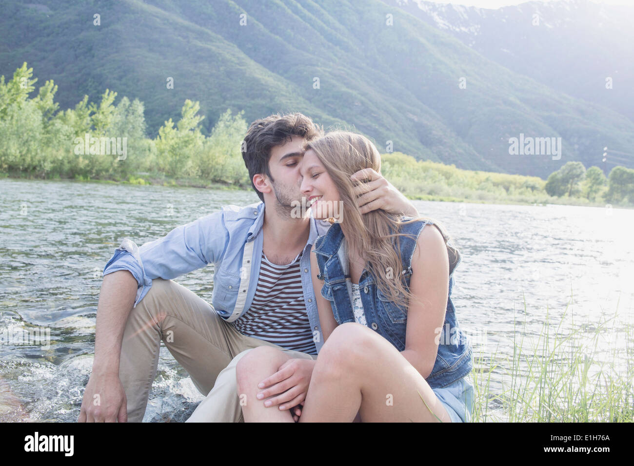 Jeune homme embrassant petite amie sur Toce riverbank, Piemonte, Italie Banque D'Images