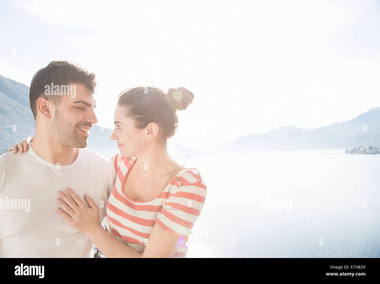 Jeune couple en face du lac et montagnes Banque D'Images