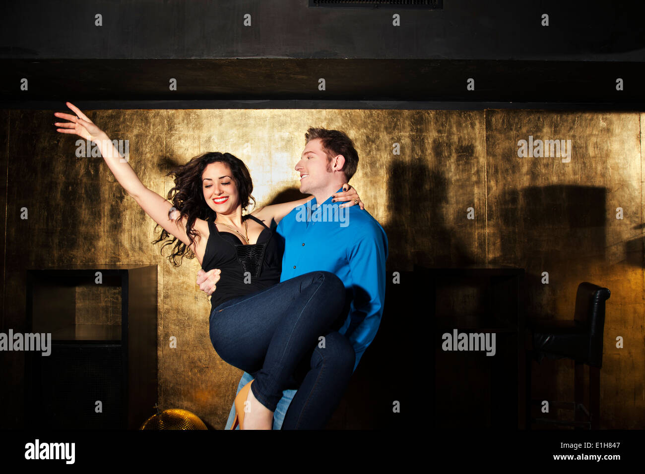 Jeune homme danse et exerçant son jeune femme en discothèque Banque D'Images