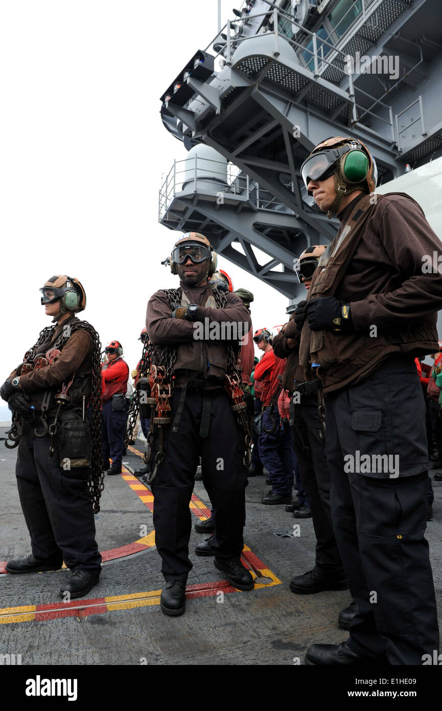L'aviation de la Marine américaine Boatswain's mates handling affecté à l'Escadron d'hélicoptères de combat de la mer (HSC) 6 attendre à lier tout avion à t Banque D'Images
