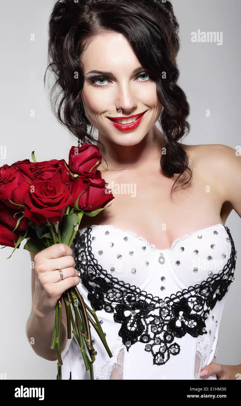 Le parfum. Belle Jeune femme tenant bouquet de roses rouges. Valentine's Day Banque D'Images