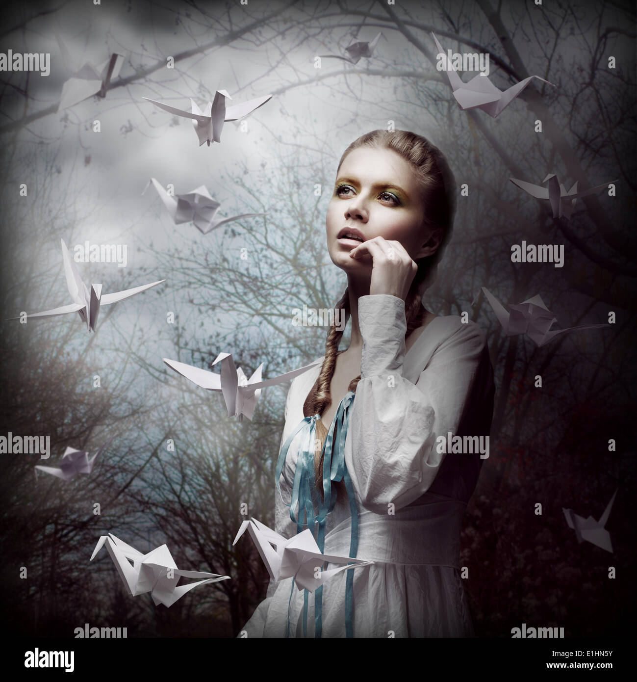 L'inspiration. Femme avec l'Origami Blanc volant de cygnes dans Dark Mystic Forest Banque D'Images