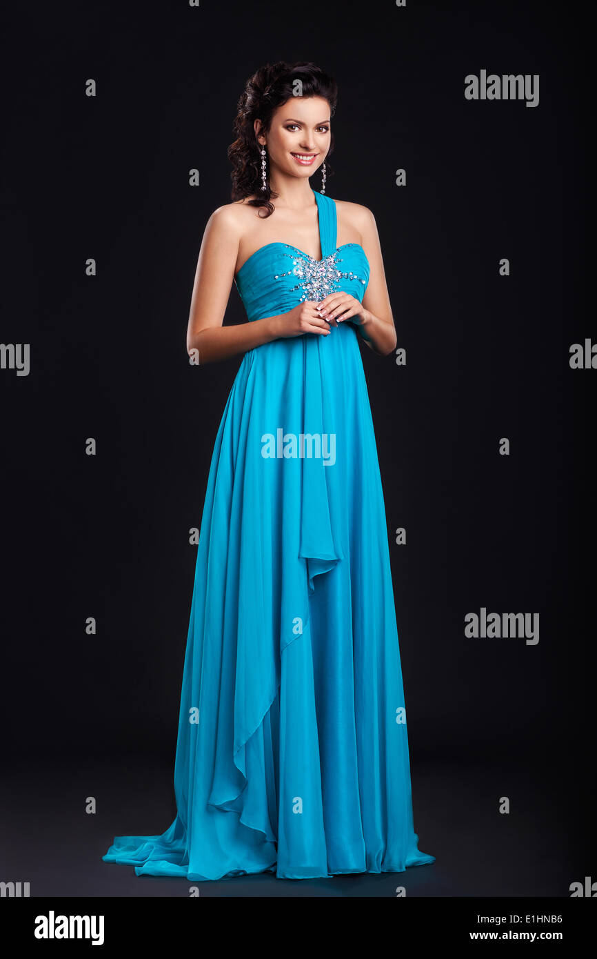 Portrait de jeune femme à la mode dans le quartier branché de robe bleue smiling over fond noir Banque D'Images