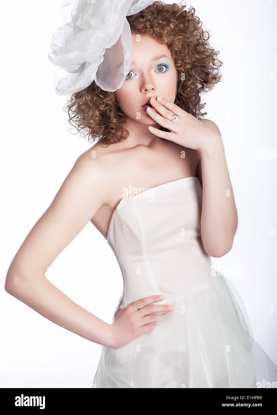 Jolie jeune femme a surpris en robe de mariée blanche isolée Studio shot Banque D'Images