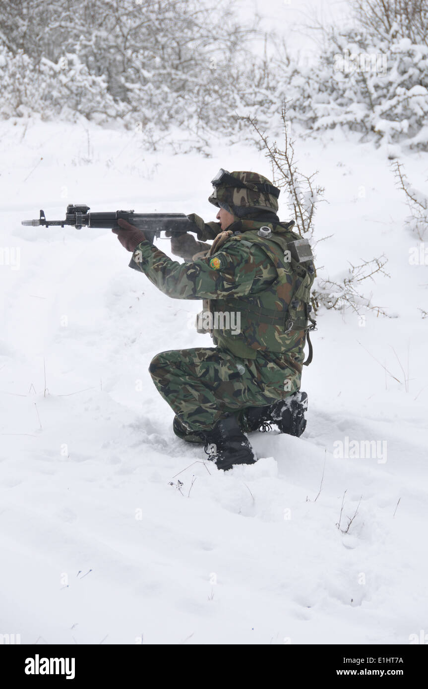 Un soldat bulgare vise vers le bas la vue d'un fusil AK-47 pendant une opération de bouclage et de recherche dans le cadre d'une équipe de conseiller militaire (MAT) t Banque D'Images