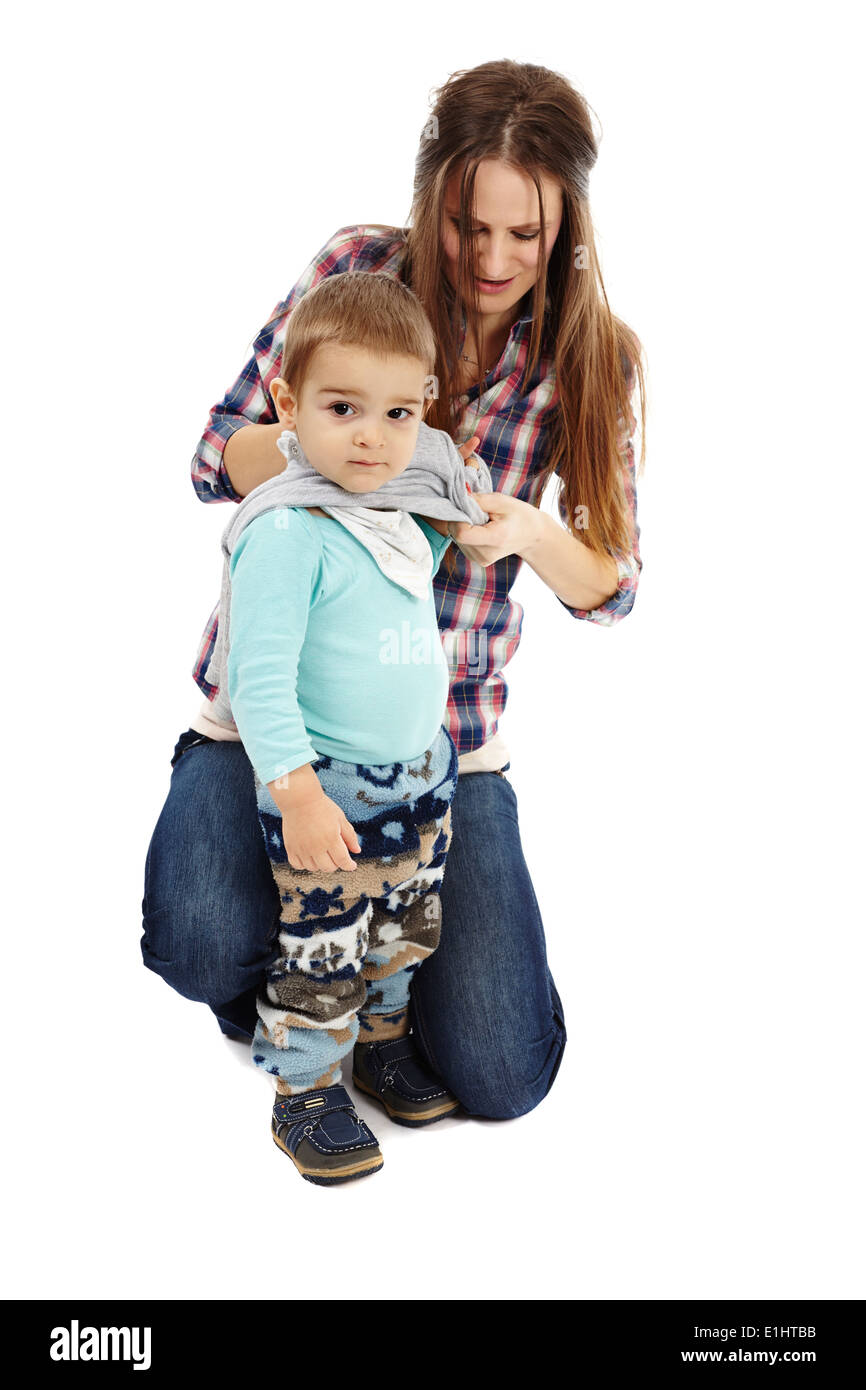 Young caucasian mother s'habillant avec son petit garçon, isolé sur fond blanc Banque D'Images