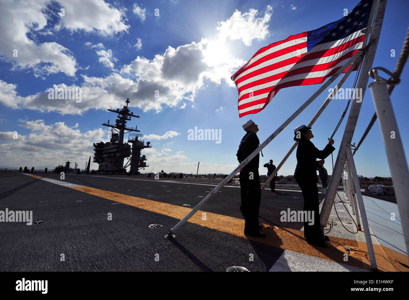L'aviation de la Marine américaine Boatswain's Mates (manutention) 3e classe Joe Montez, gauche, et Elizabeth Mongkhonvilay shift les couleurs à bord Banque D'Images