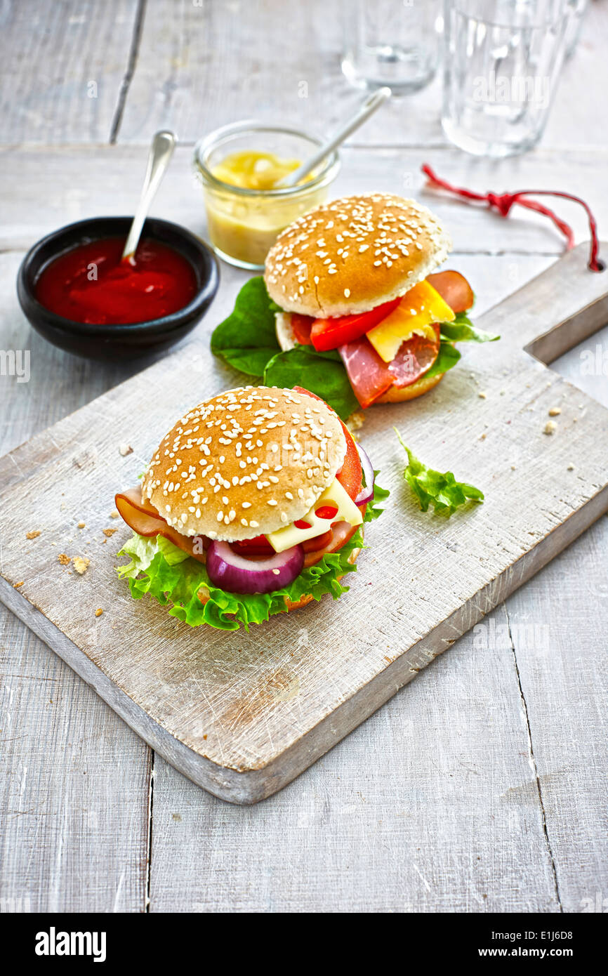 Deux préparé des hamburgers, de la moutarde et du ketchup sur sol en bois Banque D'Images