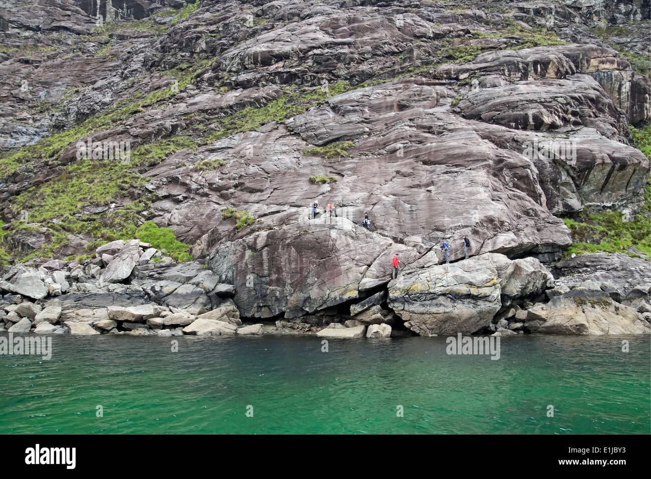 Groupe de marcheurs passant sur la mauvaise étape à Loch Scavaig Île de Skye Highland Ecosse Banque D'Images